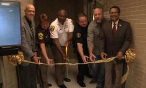 Cutting the ribbon on renovations to the first floor of the Newport News City Jail are City Manager Jim Bourney, Capt. J. Vergakis, Booking and Records Administrator, Sheriff Gabe Morgan, NNPD Lt. M. Hudgins, NNPD D. Gagne and Newport News Mayor McKinley Price.